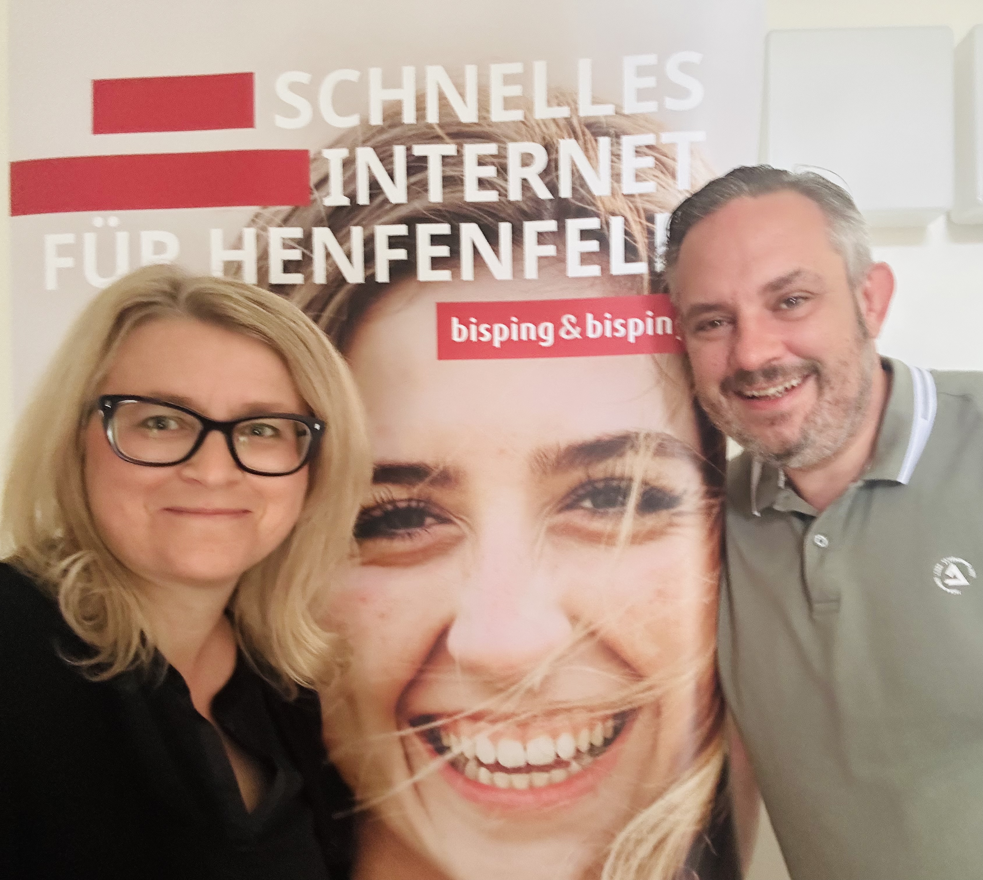 Vertragsunterzeichnung für den Glasfaserausbau in Henfenfeld: Bürgermeister Markus Gleißenberg und Johannes Bisping unterzeichnen die Kooperationsvereinbarung, begleitet von weiteren Projektbeteiligten vor dem Bisping & Bisping Banner.